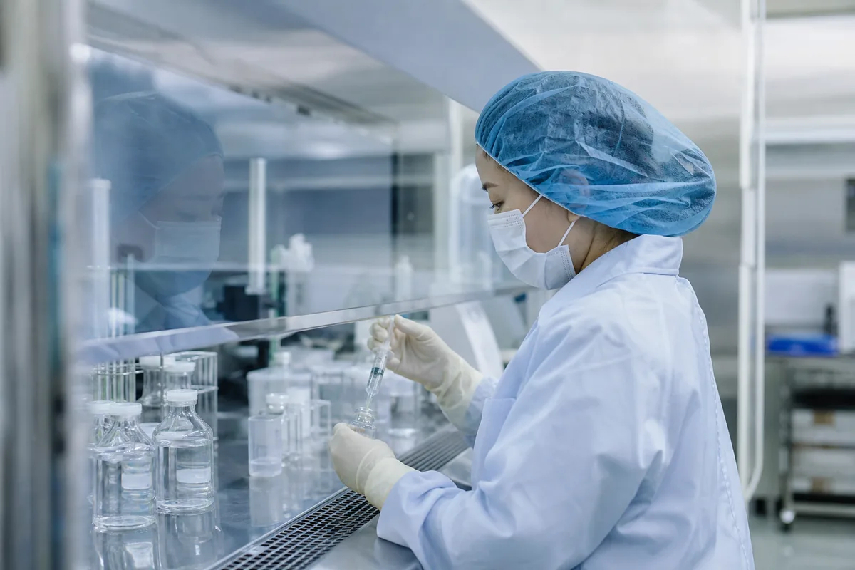 無菌調剤室でクリーンベンチに向かう薬剤師