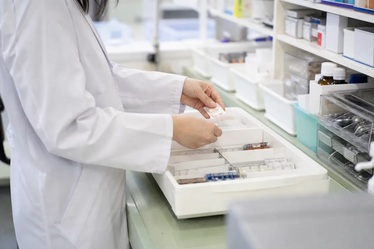 調剤カウンターで薬を扱う薬剤師の手元
