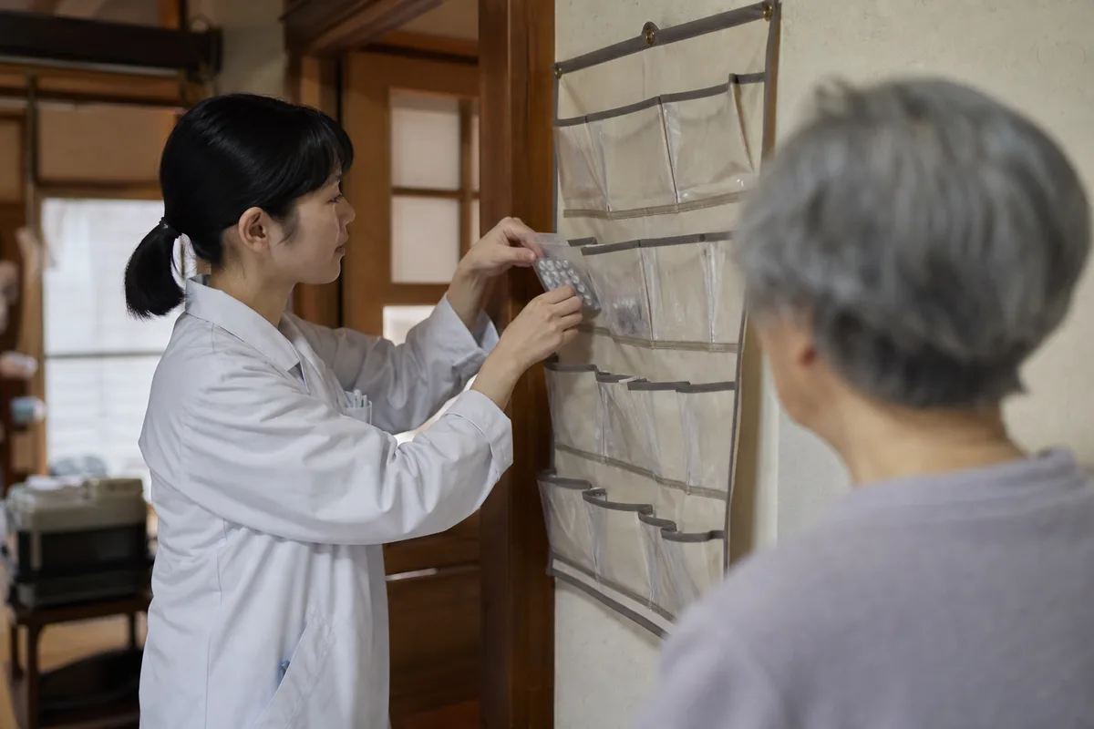 服薬カレンダーに薬をセットする薬剤師